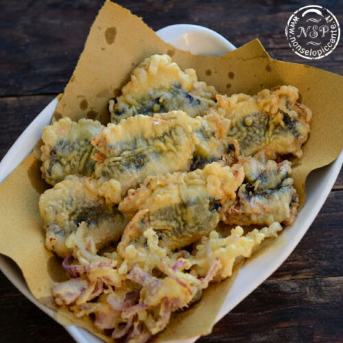 piatto di sarde fritte su tagliere rustico