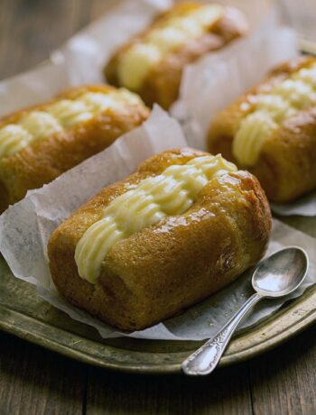 Babà all'arancia lucido di gelatina, farcito con crema diplomatica e scorze d'arancia