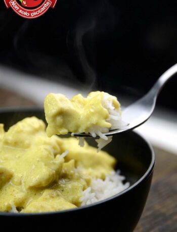 Pollo al curry con salsa chiara e speziata servito sul riso basmati in una ciotola