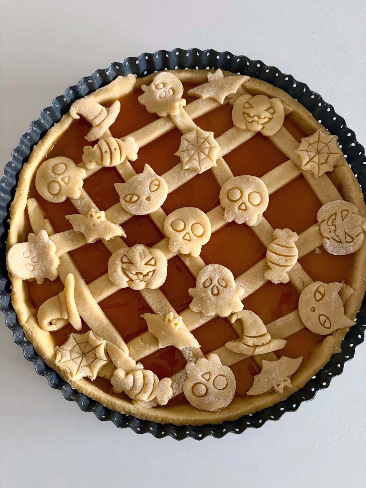 Crostata di Halloween da cuocere alla confettura di albicocche, con la grata e le figurine di frolla a forma di zucca e teschio
