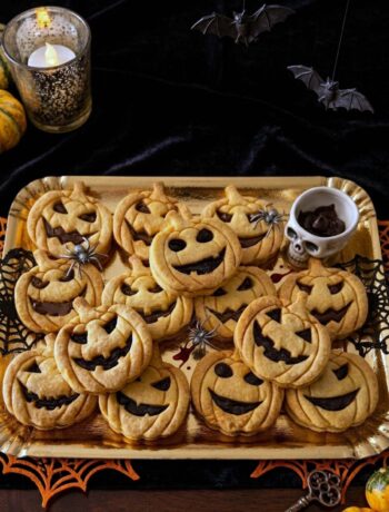 Vassoio di biscotti di Halloween senza uova a forma di zucca, fantasma e pipistrello, con glassa arancione e cioccolato
