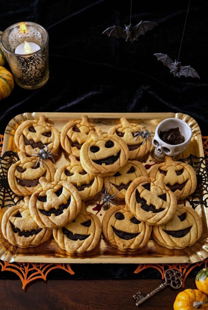 Vassoio di biscotti di Halloween senza uova a forma di zucca, fantasma e pipistrello, con glassa arancione e cioccolato
